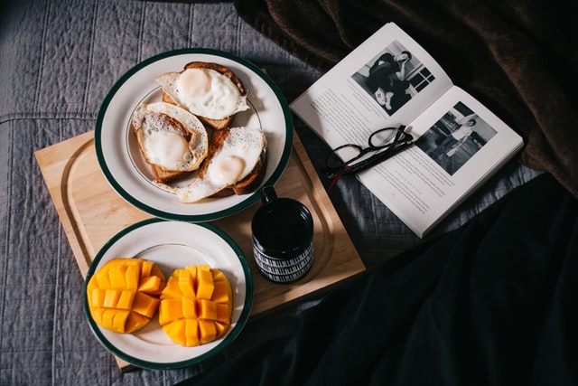image de plateau avec des tranches de mangue et des toasts accompagnés d'un livre